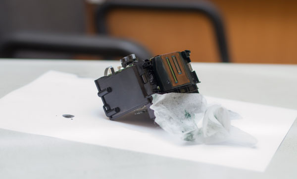 Printhead Being Cleaned Blocked print head on table with tissue ready to clean