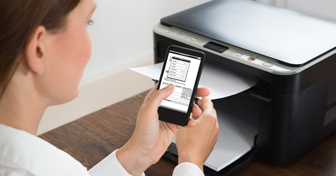 Mobile Printing Holding a mobile in front of a printer.