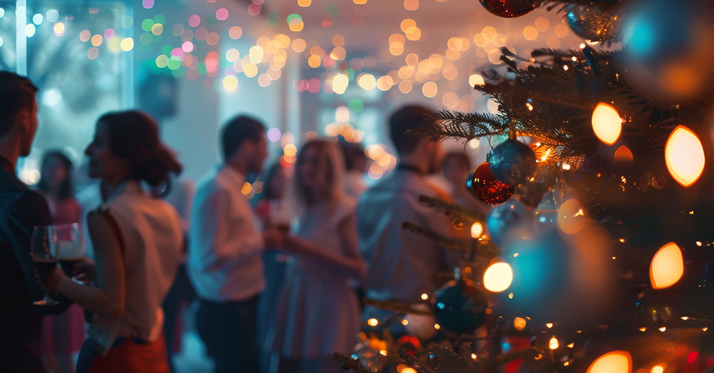 Work Christmas Party Christmas tree with a blurred background of partygoers in party attire.