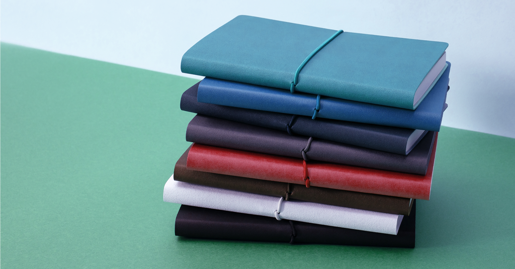 Softcover Notebook A pile of softcover notebooks.